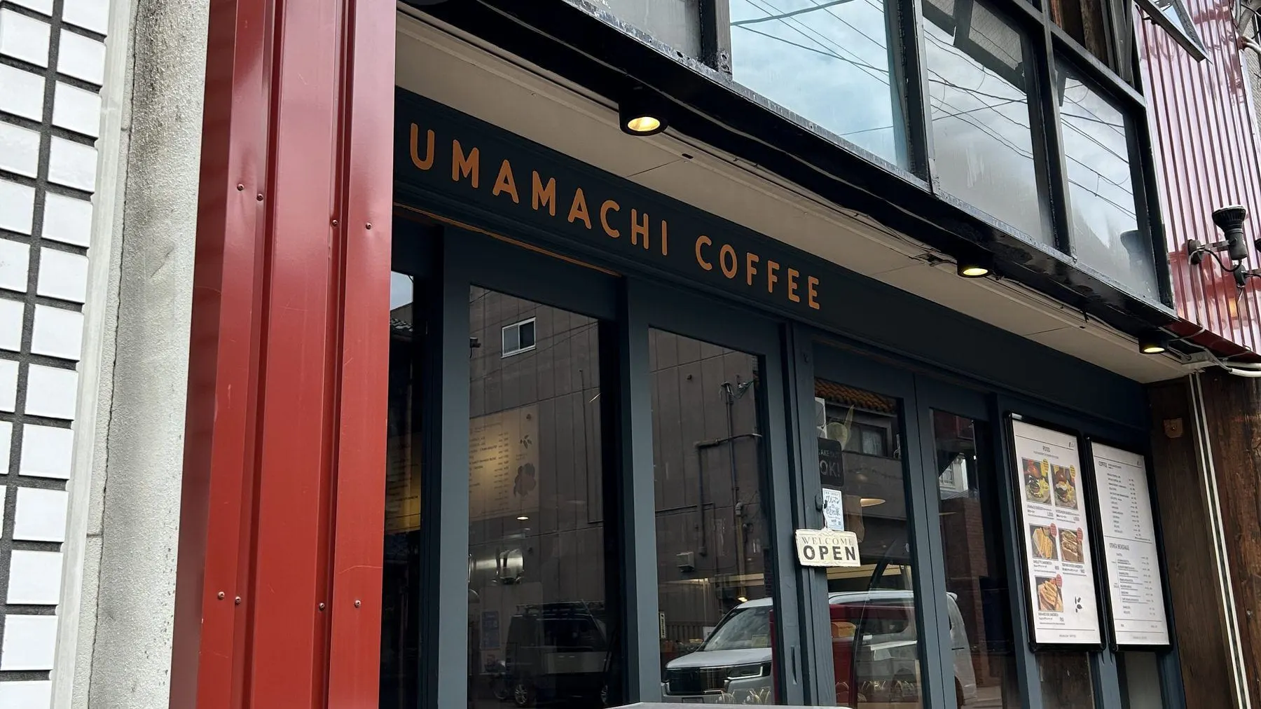 우마마치 커피 외관. 붉은 기둥과 UMAMACHI COFFEE 간판